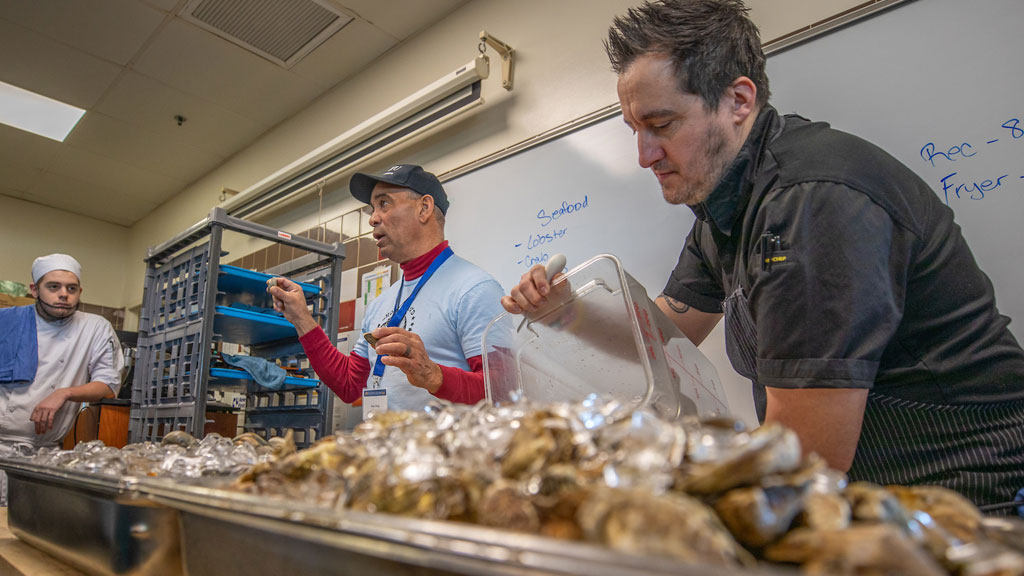 Shellfisherman Jody King (center left) and Chef Derek Wagner (right). 